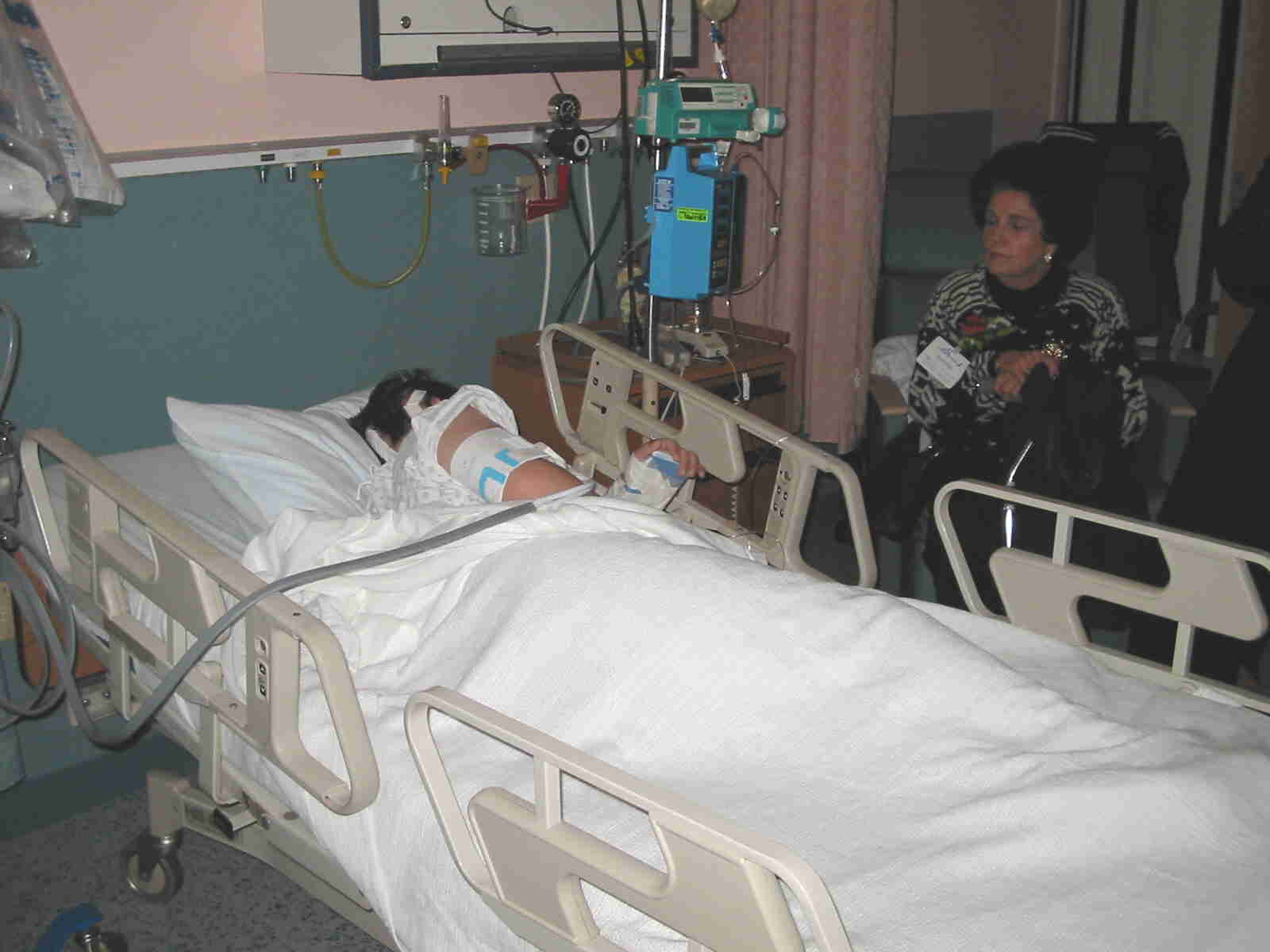Isaac recovering in hospital bed while Margaret looks on